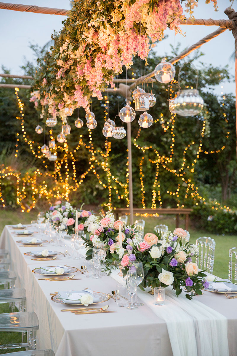 Candlelit dinner table styled with tropical florals